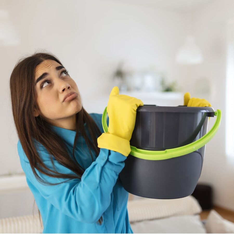 Mujer de la limpieza con un cubo en las manos y cara de preocupación